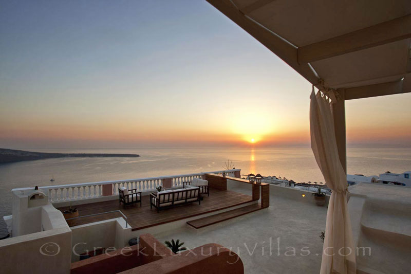 Panoramic sunset view from the roof terrace of a luxury villa in Oia, Santorini