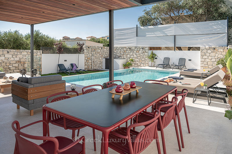 outdoor dining area by the pool in modern villa in Greece