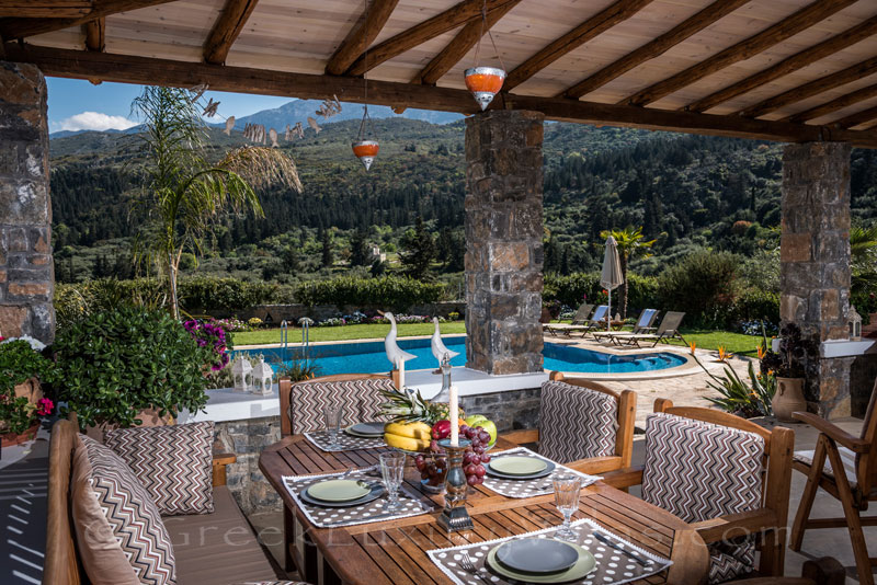 Veranda and outdoor dining area with view to nature in luxury villa with pool in Crete