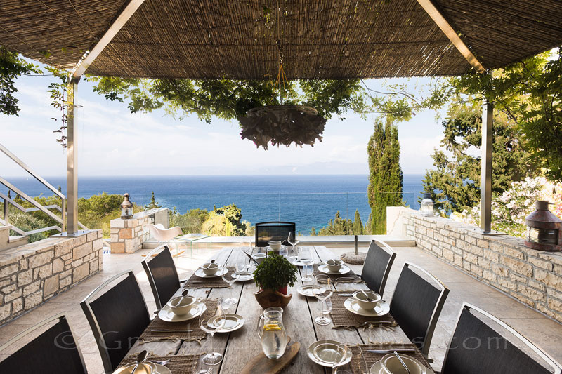 outdoor dining with seaview luxury villa on the beach Paxos