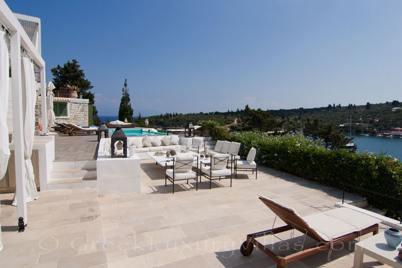 A terrace of a waterfront luxury villa with a boat jetty in Paxos