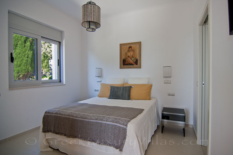 A bedroom in a modern luxury villa with a pool in Paxos