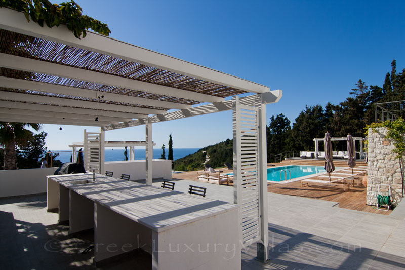 The pool bar of a modern luxury villa with a pool and seaview in Paxos