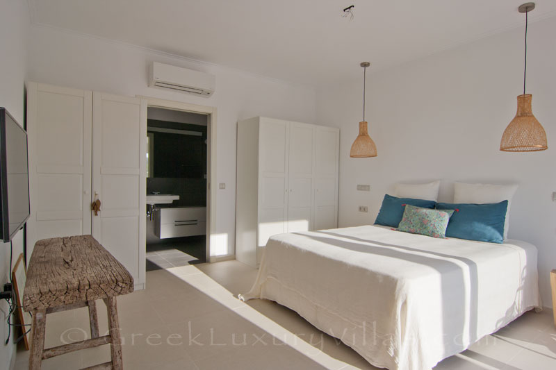 A bedroom in the guest house of a modern luxury villa with a pool in Paxos